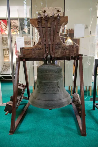 Historický zvon připomínající původní využití budovy